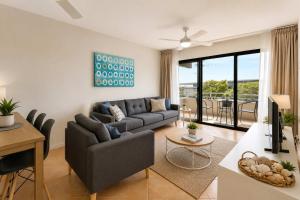a living room with a couch and a table at Warroo Apartments in Alexandra Headland