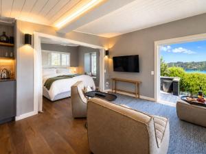 a large bedroom with a bed and a large window at Smiths Cottage - Stay Waiheke in Oneroa