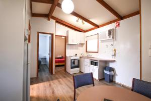 a kitchen with white cabinets and a table and chairs at Horsham Holiday Park in Horsham
