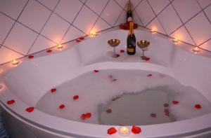 a bath tub filled with hearts and a bottle of wine at Central House in Reggio di Calabria