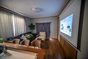 a living room with a couch and a flat screen tv at 春日レジャーホテル in Fukuoka