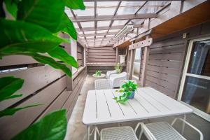 a porch with a table and chairs and plants at 春日レジャーホテル in Fukuoka