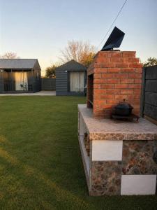 a grill on a brick wall in a yard at Elite Luxe Cabin Suite in Welkom