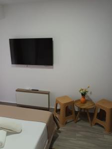 a living room with a couch and tables and a flat screen tv at Sea View Apartments Olimp by Stela in Olimp