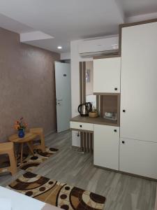 a kitchen with white cabinets and a table at Sea View Apartments Olimp by Stela in Olimp