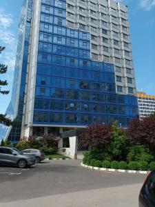 a large building with cars parked in a parking lot at Sea View Apartments Olimp by Stela in Olimp