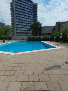 an empty swimming pool with a tall building in the background at Sea View Apartments Olimp by Stela in Olimp