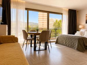 a hotel room with a bed and a table and chairs at La Marina Cannes Suites in Mandelieu-La Napoule +79 photos