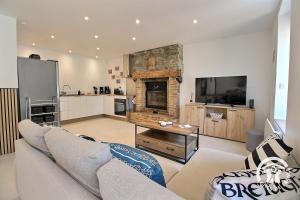 a living room with a couch and a fireplace at De la roche in Langourla