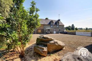 a house with a rock in front of it at De la roche in Langourla