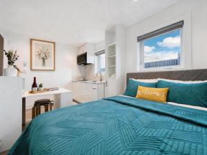a bedroom with a blue bed and a window at Vancouver Mandy Laneway Home in Vancouver