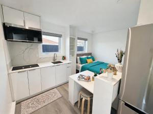 a kitchen with white cabinets and a blue couch at Vancouver Mandy Laneway Home in Vancouver +13 photos
