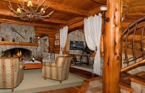 Cabaña de madera con sala de estar con chimenea en Las Baitas en San Carlos de Bariloche