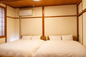 two twin beds in a room with a heater at オオジンマチ ハイツ302 in Takayama