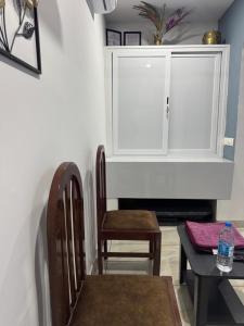 a dining room with a white cabinet and chairs at Nandbhavan Guruvayur in Guruvāyūr