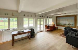 a living room with a table and chairs and windows at Beautiful Home In Øster Ulslev With Wifi in Øster Ulslev