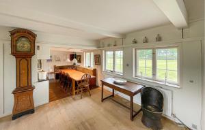 a room with a table and a grandfather clock in it at Beautiful Home In Øster Ulslev With Wifi in Øster Ulslev