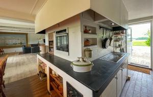 a large kitchen with a counter top with a stove at Beautiful Home In Øster Ulslev With Wifi in Øster Ulslev