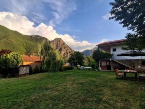 a yard with a table and a house and mountains at ILIS House Matka Canyon - 2 in Skopje