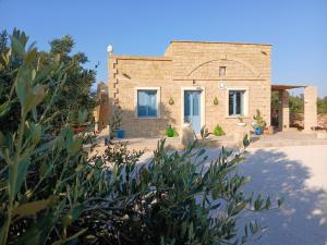 a brick house with a plant in front of it at Casale Mute Terre in Tuglie