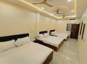 a bedroom with two beds and a ceiling at The Comfort Villa in Ujjain