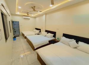 a hotel room with two beds and a room with two beds at The Comfort Villa in Ujjain