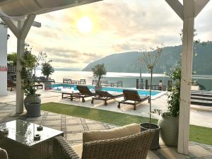 a patio with tables and chairs and a view of the water at Serenity in Eşelniţa +9 photos