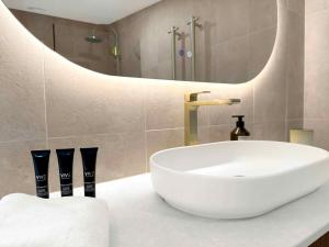 a bathroom with a white sink and a mirror at Highwoods Cottage in Pokolbin +14 photos