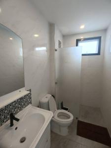 a white bathroom with a toilet and a sink at Lamai Sunshine Villas in Hua Thanon Beach