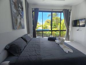 a bedroom with a large bed with a large window at Lamai Sunshine Villas in Hua Thanon Beach