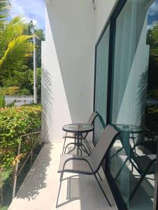 a balcony with two chairs and a table at Lamai Sunshine Villas in Hua Thanon Beach