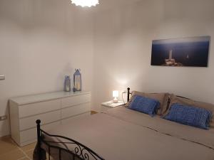 a bedroom with a bed with blue pillows on it at Casale Mute Terre in Tuglie +7 photos