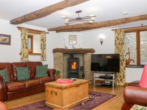 a living room with a couch and a fireplace at The Hay Barn in Halwell