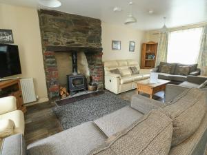 a living room with a couch and a fireplace at Halford Hill in Llanberis