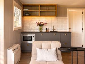 a kitchen with a couch and a table in a room at Smiths Cottage - Stay Waiheke in Oneroa