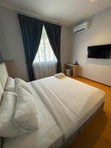 a bedroom with a large white bed with a window at DBC Hotel in Semporna +35 photos