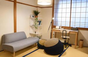 a living room with a chair and a desk at オオジンマチ ハイツ302 in Takayama