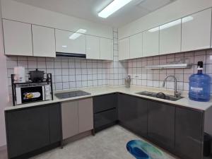 a kitchen with white cabinets and a sink at clark terrace condo with 2bedroom near airport hann casino in Tibo