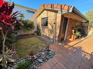 a brick house with a yard with a driveway at Arcos in Hat Head