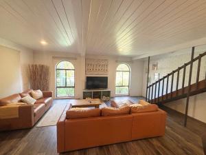 a large living room with couches and a tv at Arcos in Hat Head