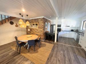 a kitchen and dining room with a table and chairs at Arcos in Hat Head
