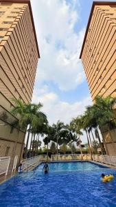 a large pool with palm trees in front of two buildings at clark terrace condo with 2bedroom near airport hann casino in Tibo