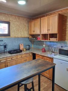 a kitchen with wooden cabinets and a table in it at Гостевой дом Chimgan Apple Garden in Chimgan