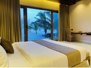 a bedroom with a bed and a view of the beach at Beach Escape in Arugam Bay