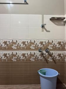 a bathroom with a shower with a bucket at Nandbhavan Guruvayur in Guruvāyūr