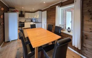 a kitchen and dining room with a wooden table and chairs at Stunning Home In Treungen in Treungen