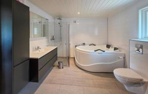 a bathroom with a tub and a sink and a toilet at Stunning Home In Treungen in Treungen