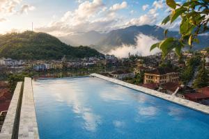 a large swimming pool with a view of a city at Sapa Village Hotel in Sapa