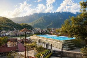 a swimming pool with a view of a city and mountains at Sapa Village Hotel in Sapa