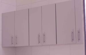 a group of white cabinets in a kitchen at Mada's House F H L in Abomey-Calavi